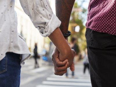 Close Up Of Couple Holding Hands On Urban Street